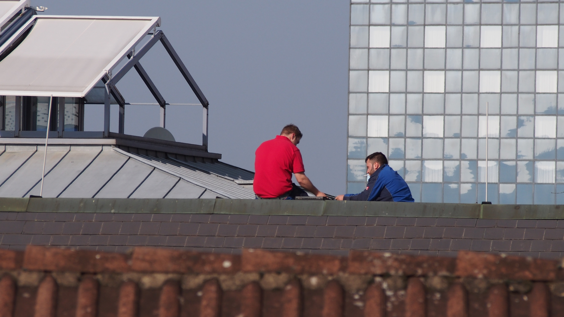 A couple of men sitting on a roof AI-generated content may be incorrect.